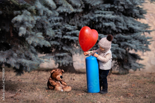 Fotografie A little boy inflates a balloon with helium