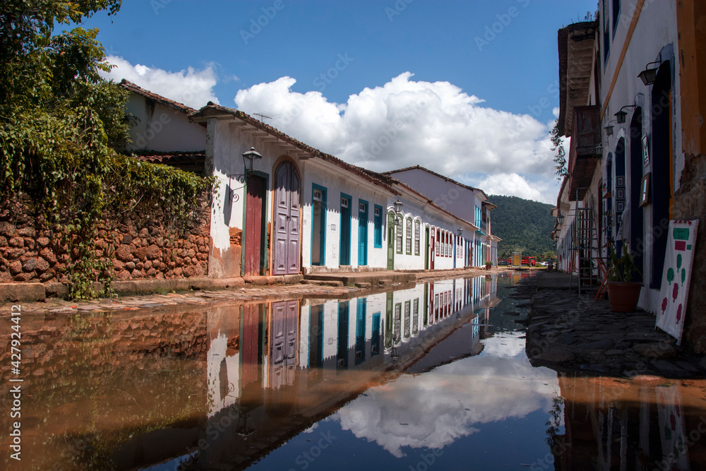 Colonial city of Paraty. Stone street flooded with water mirror reflecting colonial houses and the sky in perspective.