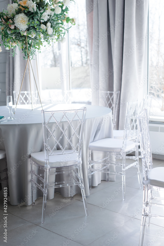 transparent plastic chairs at a round table with a blue tablecloth indoors transparent plastic chairs at a round table with a blue tablecloth indoors