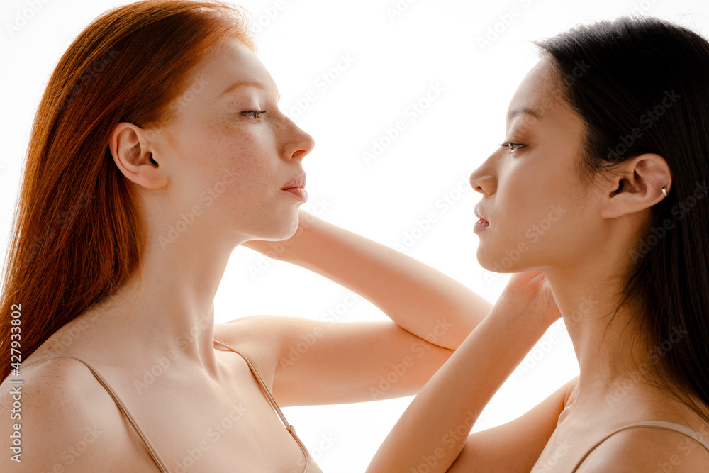 Multiracial two women posing and looking in opposite directions Multiracial two women posing and looking in opposite directions