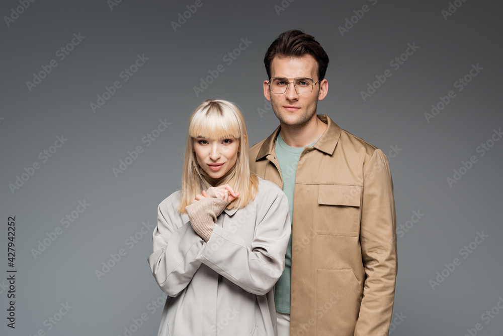 trendy models posing while looking at camera isolated on grey trendy models posing while looking at camera isolated on grey