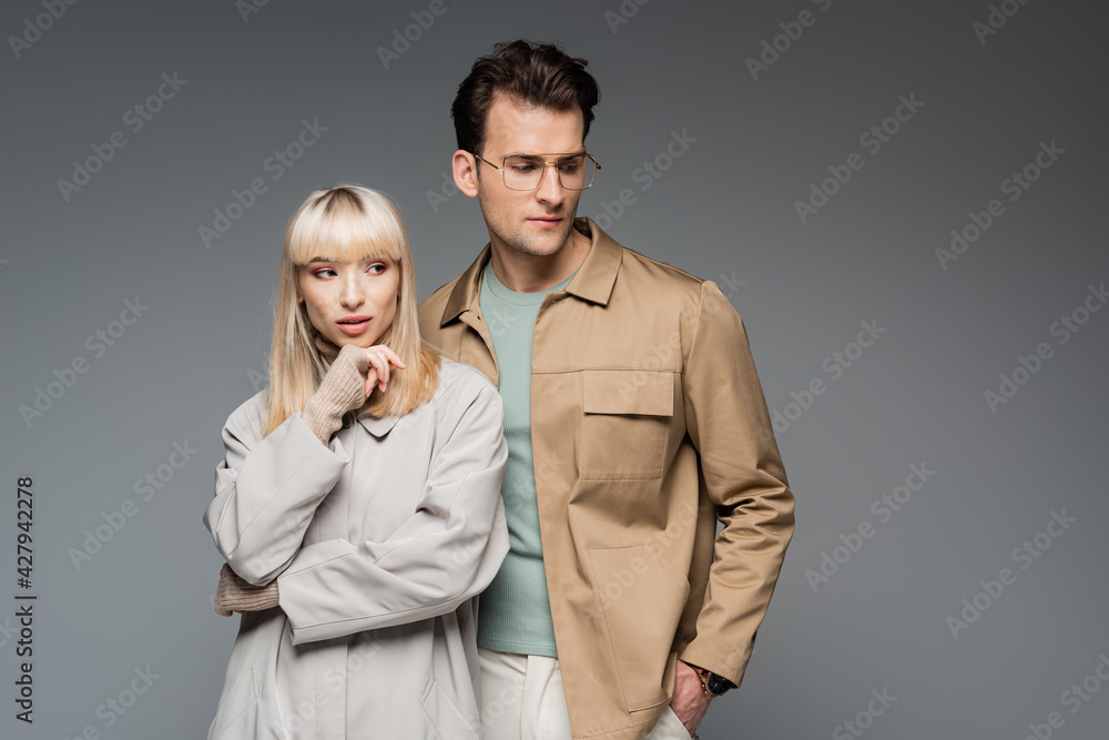 trendy models posing while standing isolated on grey trendy models posing while standing isolated on grey