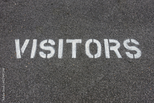 Fotografie Stenciled VISITORS Spray Painted on Pavement of Parking Lot