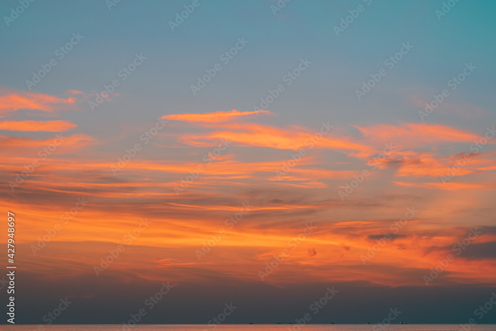 The sky at sunset at the sea beach in summer, The clouds are soft and fluffy floating on blue sky and pink and orange for backgrounds concept, Selective focus.