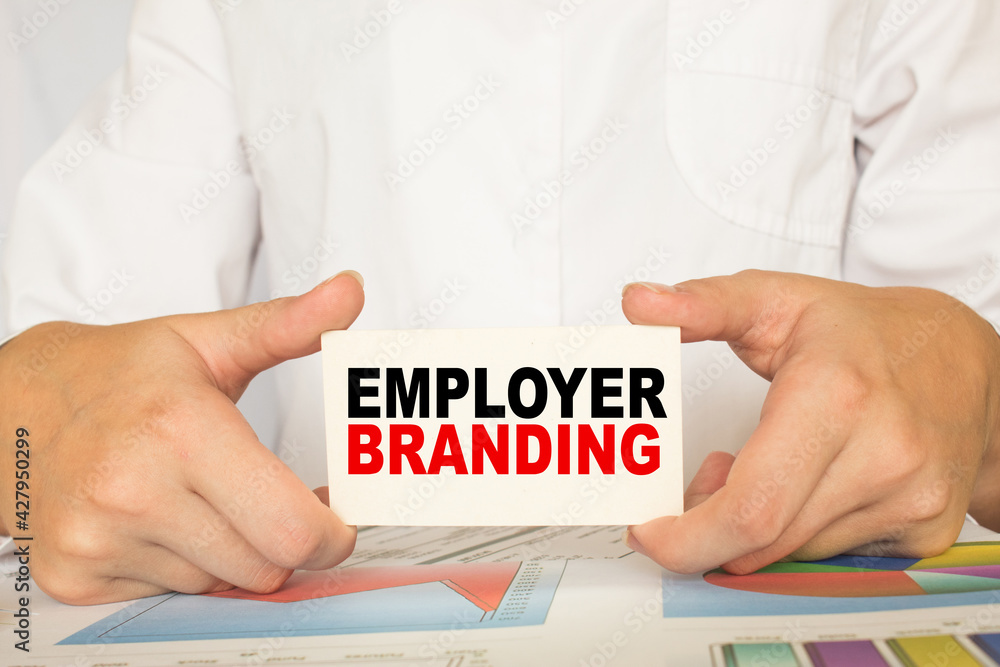 a man in the office holds a card with text EMPLOYER BRANDING . business concept a man in the office holds a card with text EMPLOYER BRANDING . business concept