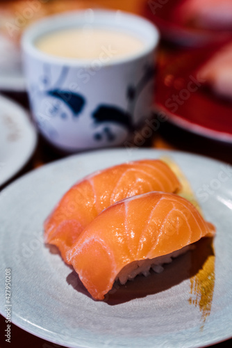 Sushi and Sashimi. Dishes of Sushi and Sashimi rolling on conveyer belt. photo