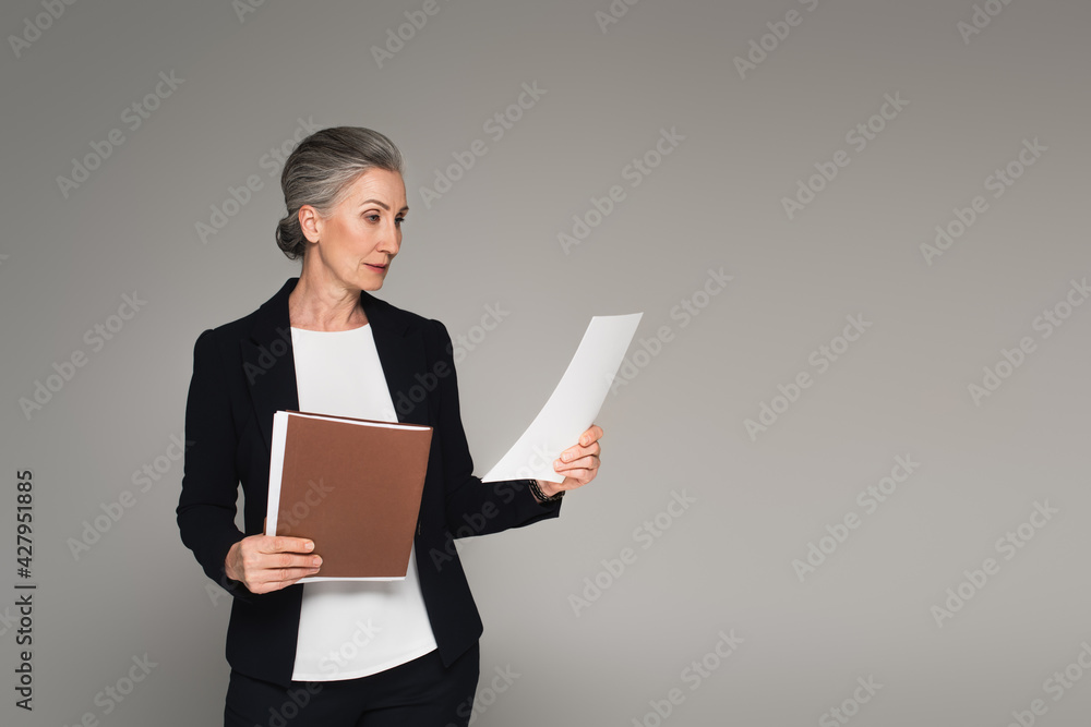 Businesswoman holding document and paper folder isolated on grey Businesswoman holding document and paper folder isolated on grey