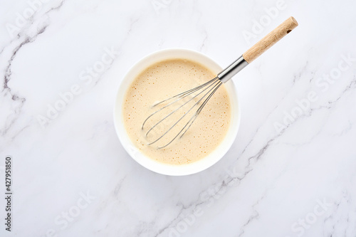 Preparation of dough for home pancakes for Breakfast or for Maslenitsa. Ingredients on the table - wheat flour, eggs, butter, sugar, salt, milk. Recipe step by step. Top view with place for text.