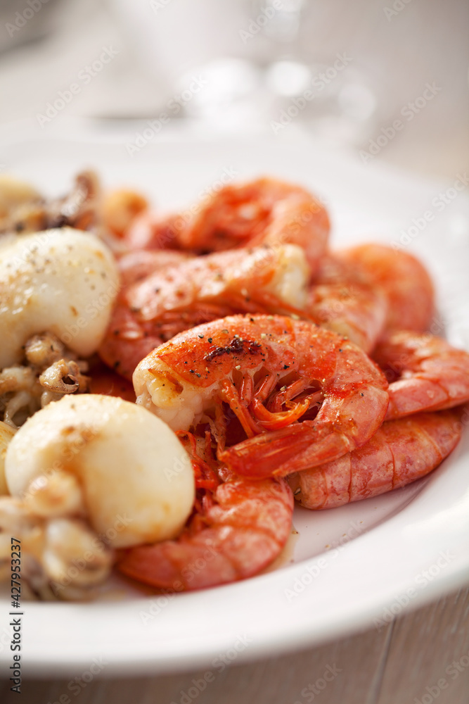 Grilled prawns and cuttlefish on a plate. High quality photo. Grilled prawns and cuttlefish on a plate. High quality photo.