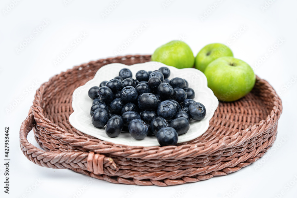 Summer harvest of fresh ripe blueberries and green apples in a basket Summer harvest of fresh ripe blueberries and green apples in a basket