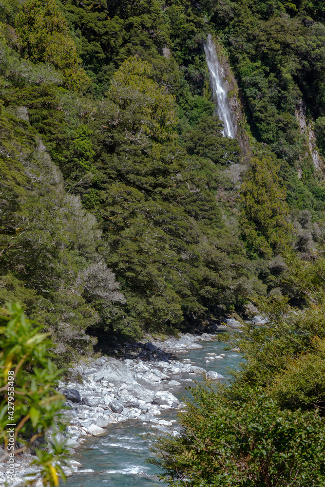 Obraz premium Rocky terrain and a waterfall at Thunder Creek in New Zealand
