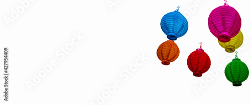 Horizontal banner of Brightly multi-colored paper laterns hanging isolated to one side of white background photo