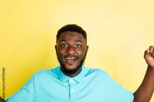 Portrait of young African man isolated over yellow studio background with copyspace.