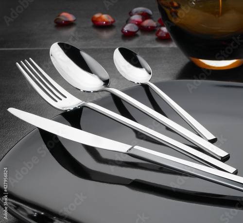 steel cutlery set on black elegant table  photo