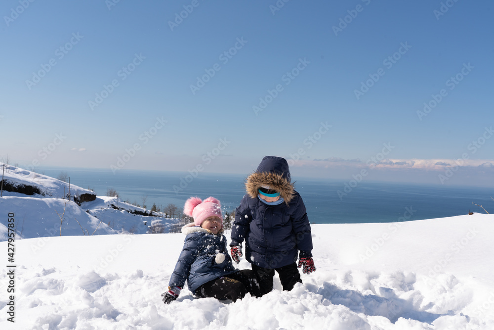 Boy and girl playing snowballs in winter Boy and girl playing snowballs in winter