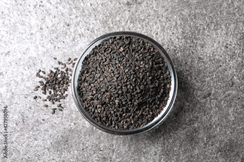 Black sesame seeds on grey table, flat lay