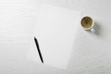 Blank paper sheet, pen and cup of coffee on white wooden table, flat lay. Space for text