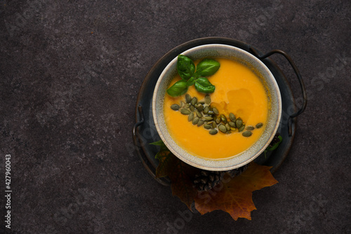 Hot autumn pumpkin soup with pumpkin seeds, copy space