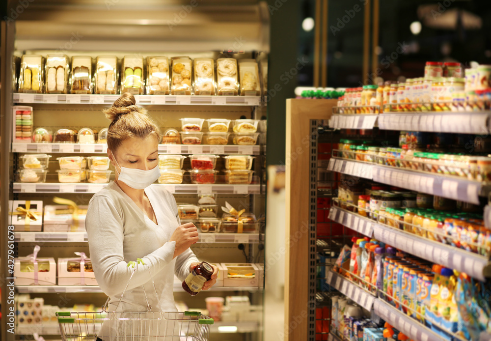 Woman reading product information.Supermarket shopping, face mask
