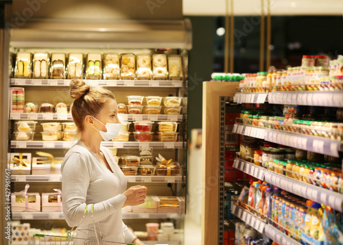 Woman reading product information.Supermarket shopping, face mask