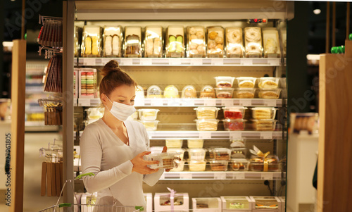 Woman reading product information.Supermarket shopping, face mask