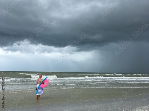 Man ready to vacation with family, but the weather has other plans. Stormy sky beach day photo