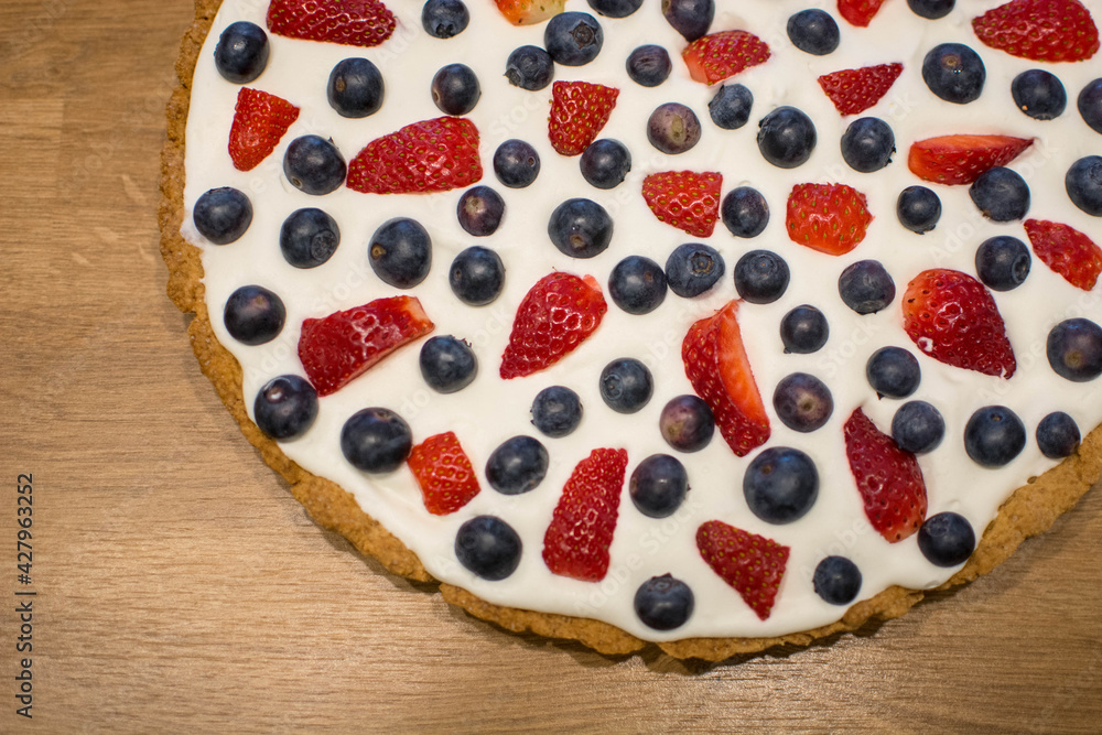 Tarta na kruchym cieście z bitą śmietaną i owocami - truskawkami i borówkami