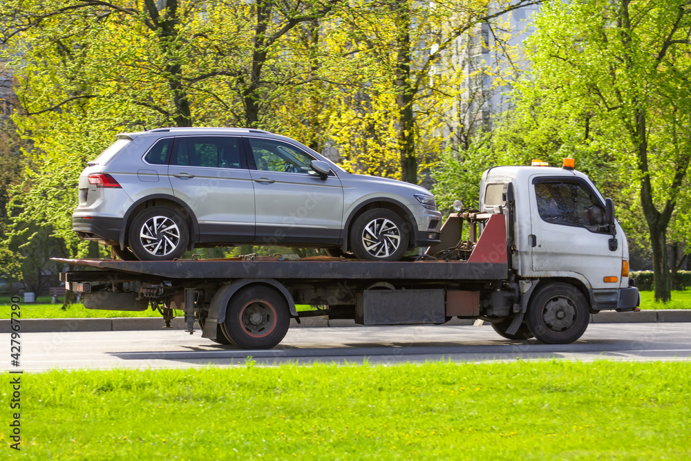 Hatchback car loaded onto a tow truck ready for transport.