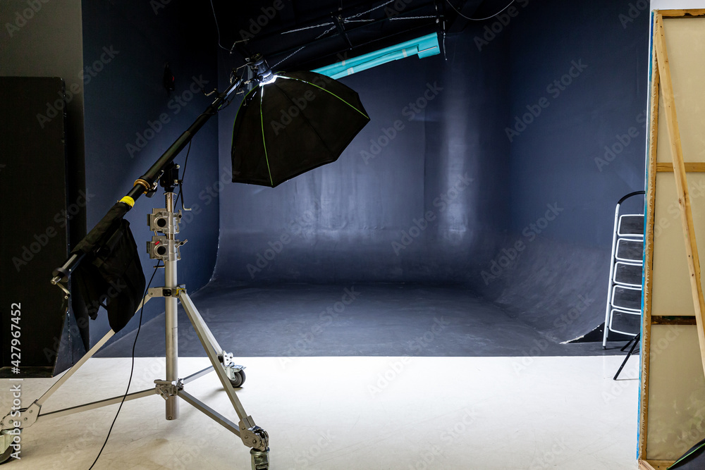 Empty photo studio with lighting equipment. Photographer workplace interior with professional tool set gear. Flash light black background scenes ready for studio shooting. Modern photographer studio