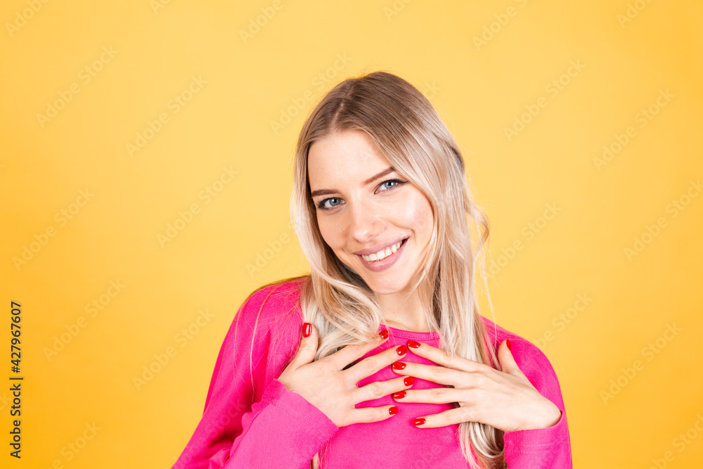 Pretty european woman in pink blouse on yellow background positive emotions smiling happy cheerful hands on chest Pretty european woman in pink blouse on yellow background positive emotions smiling happy cheerful hands on chest