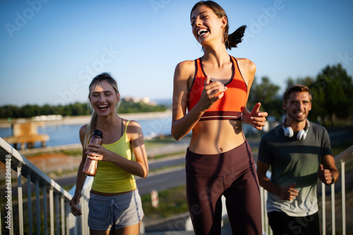 Fototapeta Naklejka Na Ścianę i Meble -  Athletic fit people exercising and running together outdoors