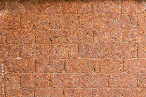 blur of red laterite brick wall Porous and fine-grained Background pattern photo