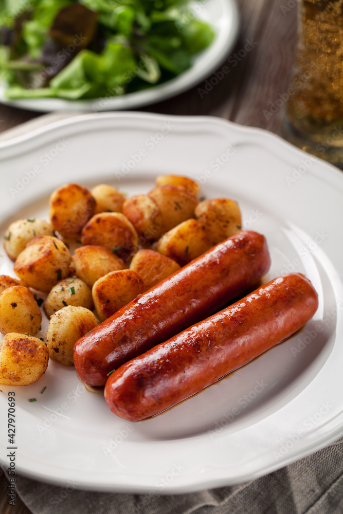 Sausages and potatoes on a plate. High quality photo. Sausages and potatoes on a plate. High quality photo.