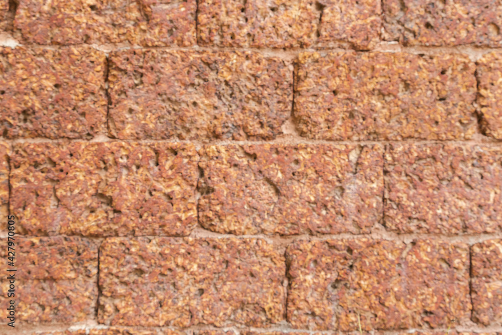 blur of red laterite brick wall Porous and fine-grained Background pattern