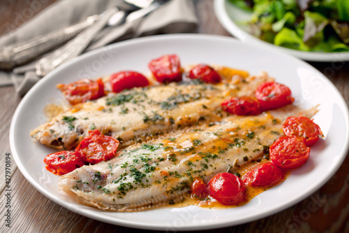 Sole with cherry tomatoes on a plate. High quality photo.