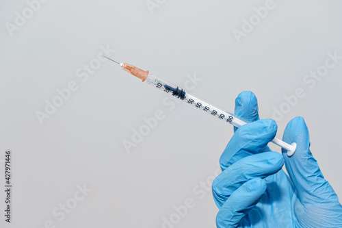 Syringe in doctor hand with protective gloves, vaccianation concept photo