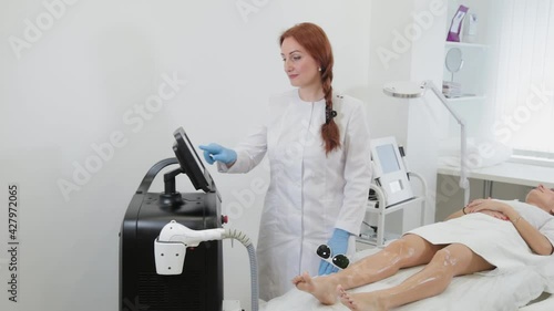 Close up of cosmetologist hands in gloves turns on laser equipment before procedure, side view. Concept beauty center, medical clinic.