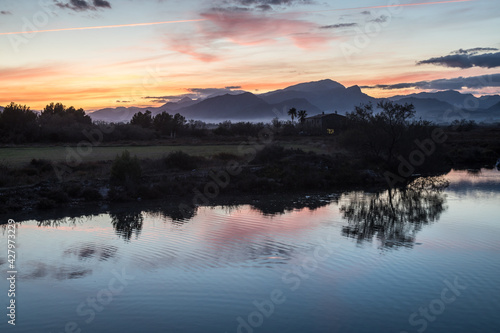 Sunset at the wetlands of Albufereta in the north of Mallorca with the mountain range Serra de Tramuntana in the background.