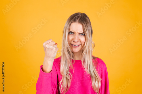 Wallpaper Mural Pretty european woman in pink blouse on yellow background shouts angrily, reproachfully accuses you, points directly to camera, blames you Torontodigital.ca