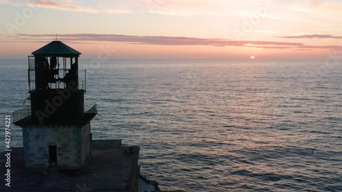 Close-Up Aerial 4K Abandoned Tillamook Oregon Rock Lighthouse At Sunset With Sea Lions, Eagles, and Crashing Waves photo