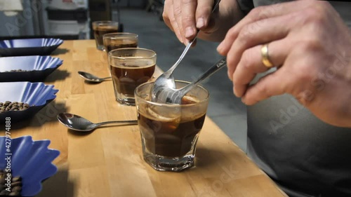 Coffee cupping, cup tasting using two spoons, slow motion close up photo