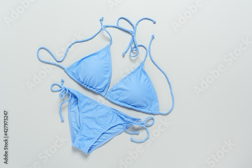 Blue female swimming wear bikini on a gray background. Top view, flat lay. photo