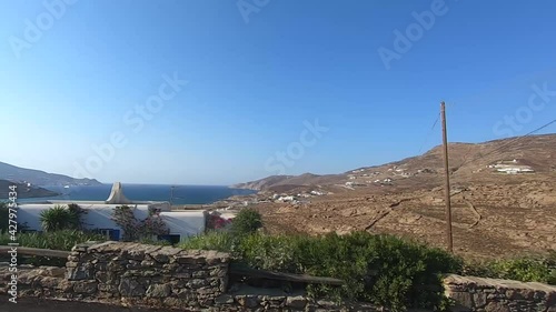 slow motion ocean view by the road on a motorbike and quad in mykonos greece during the summer season photo