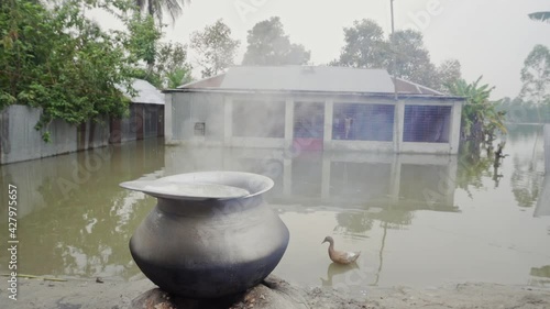 Rice is boiling in front of a flooded house. photo