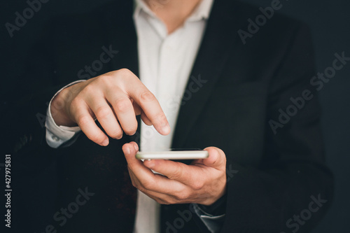 Businessman in a suit with a phone in his hands. Man with a phone in his hands
