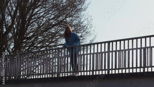 Girl standing on a Bridge thinking photo