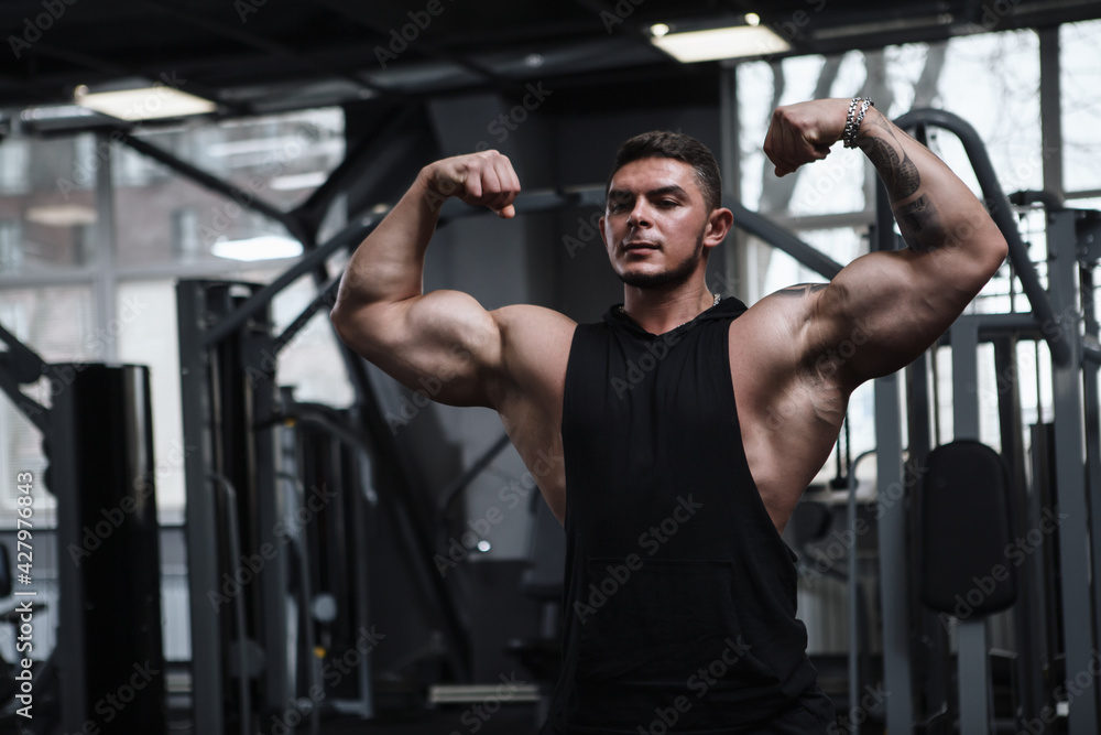 Handsome muscular sportsman flexing muscles in front of the mirror Handsome muscular sportsman flexing muscles in front of the mirror