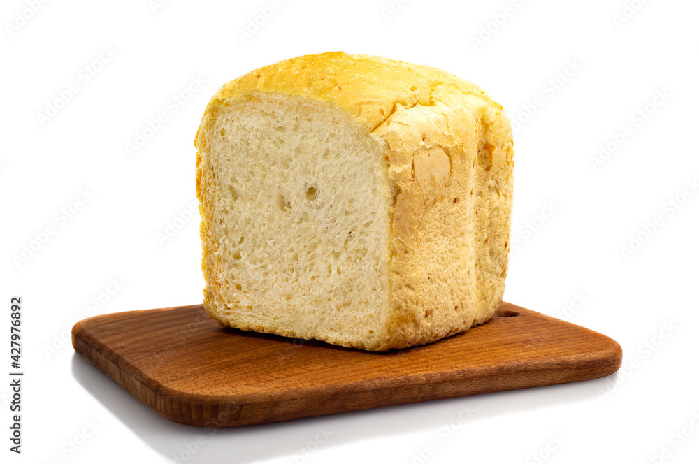 Fresh white wheat homemade bread on a wooden board, isolate. Homemade cakes, pastries Fresh white wheat homemade bread on a wooden board, isolate. Homemade cakes, pastries