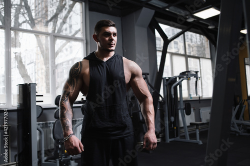 Muscular professional bodybuilder at the gym, copy space