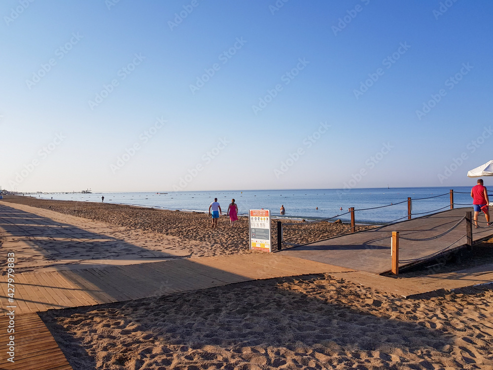 Wooden pier, beach and sun umbrellas on a sunny day.
